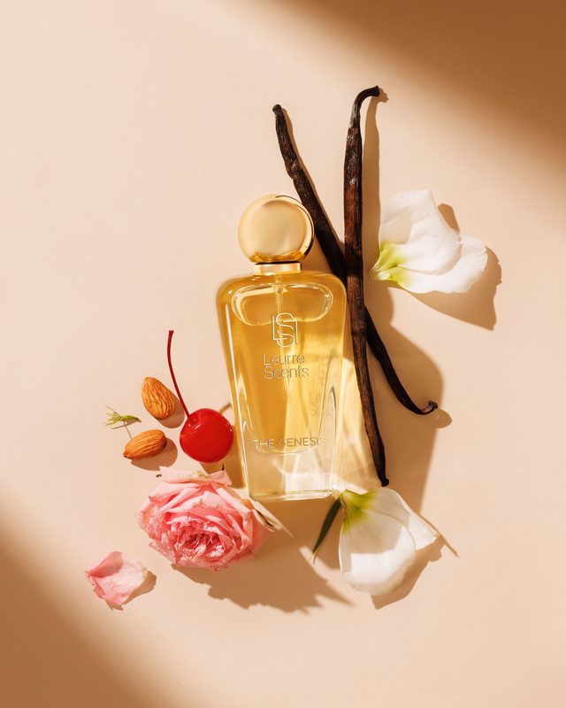 The Genesis bottle laid out with vanilla, almonds, cherry and rose petals