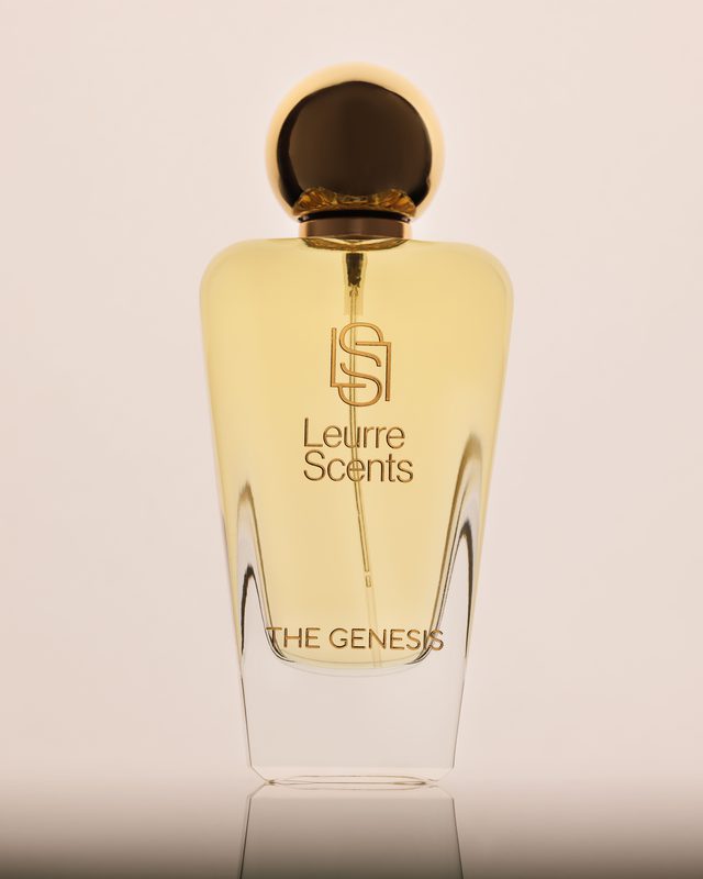 The Genesis bottle on a cream backdrop, gold sphere cap catching the light