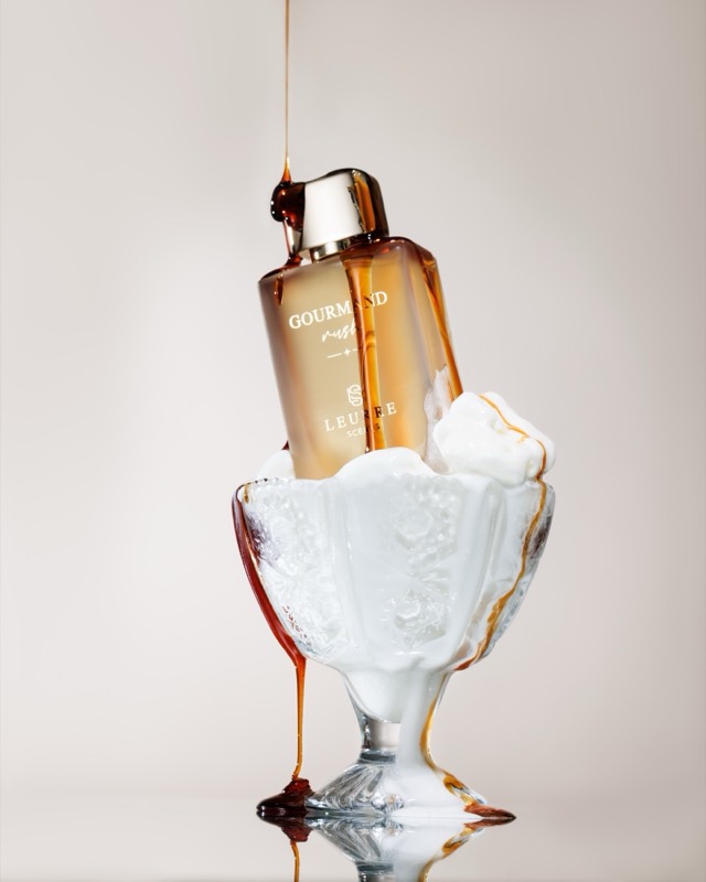 Gourmand Rush bottle in a glass sundae dish, caramel pouring over whipped cream