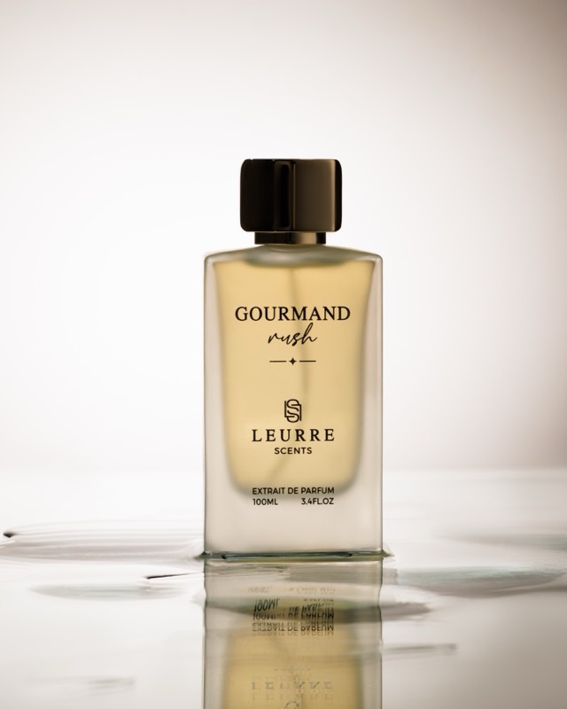 Gourmand Rush bottle standing in a shallow pool of water
